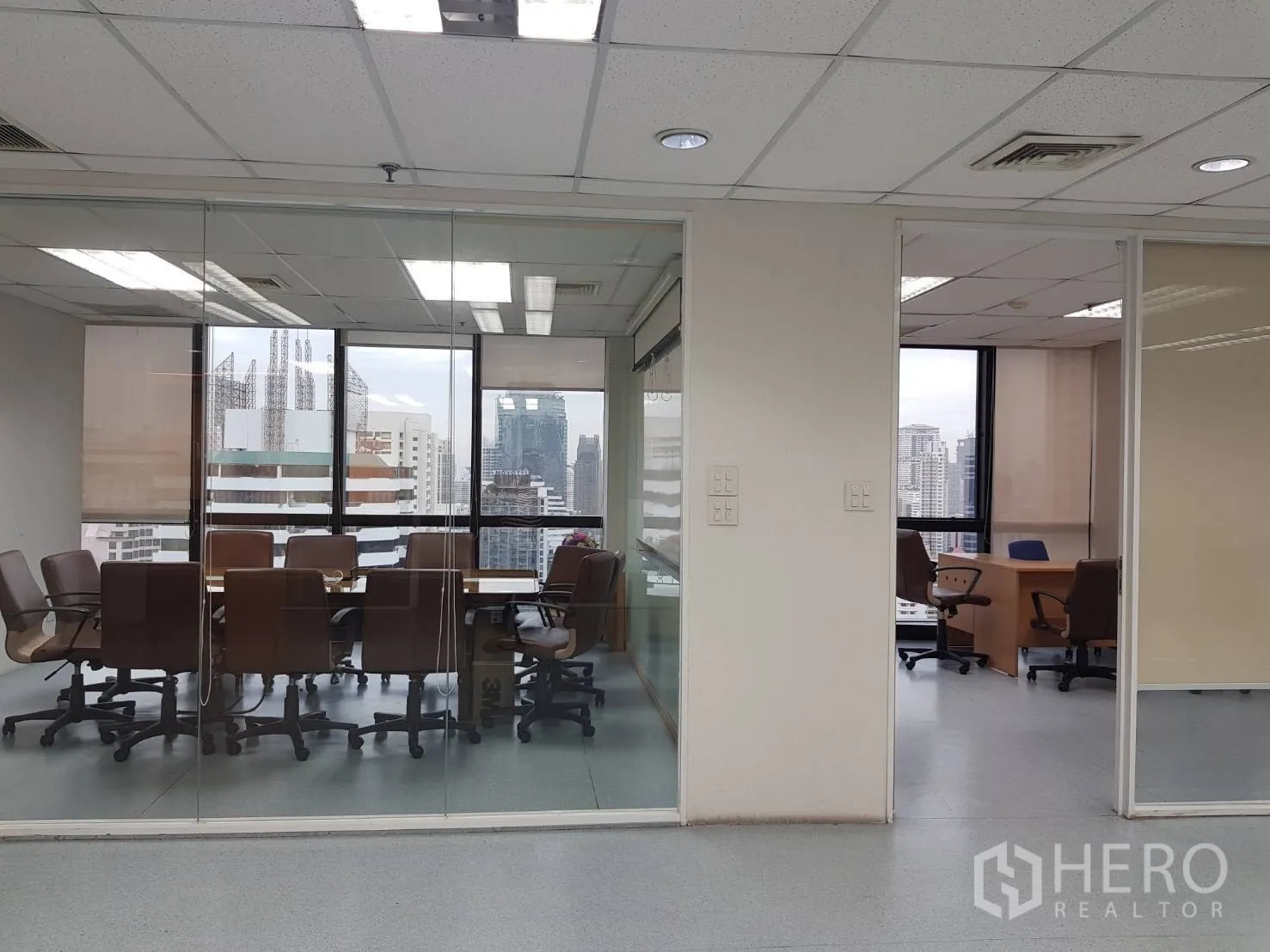 Office Space for rent in Bang Na, Bangkok - Boardroom and private office divided by clear partitions with large windows and city backdrop.