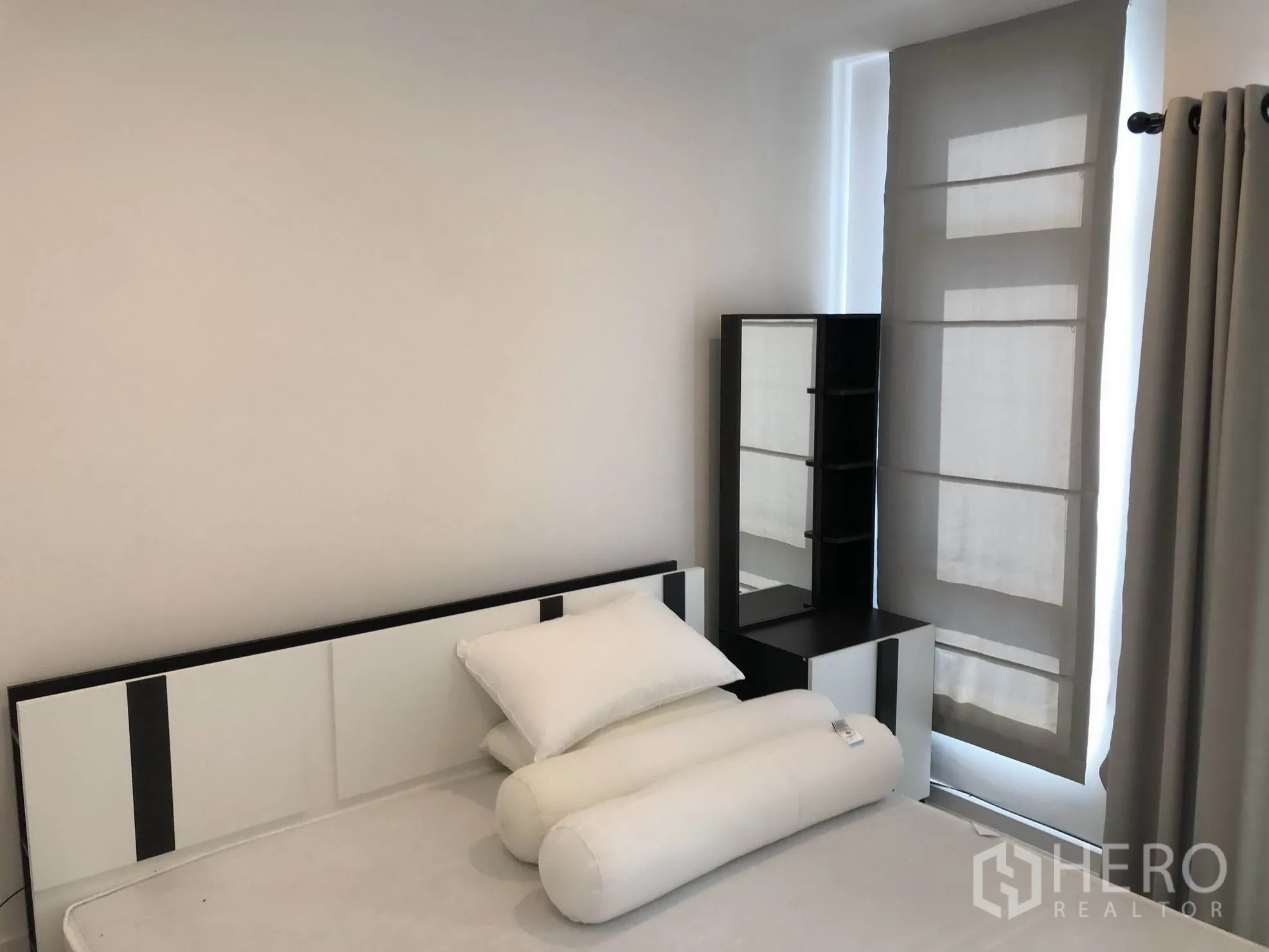 Townhouse for rent in Bang Kapi, Bangkok - Furnished bedroom with bed, pillows, dressing corner and light-filtering blinds.