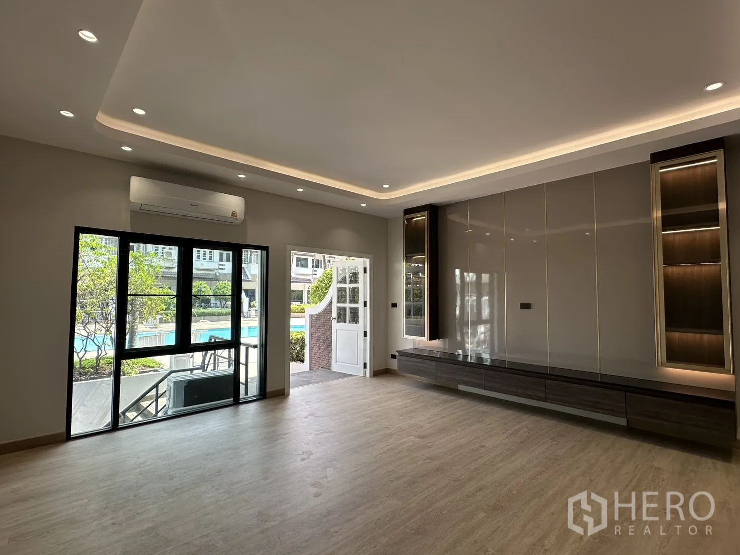 Home Office for rent in Watthana, Bangkok - Living area with sliding doors opening toward a poolside terrace.