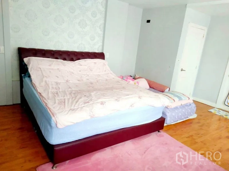 Condominium for rent in Khlong Toei, Bangkok - Spacious master bedroom with tufted headboard and additional child bed.