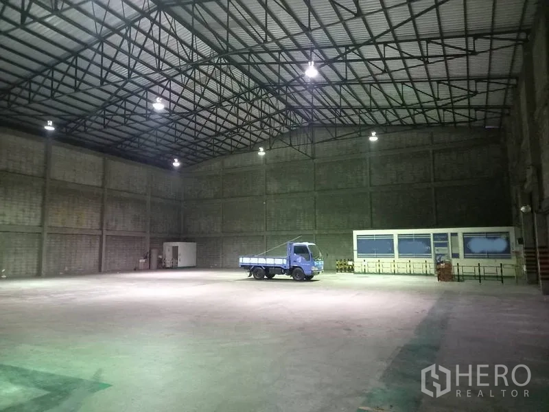 仓库 for rent in Mueang Pathum Thani, Pathum Thani - 仓库内部高挑空间，钢结构屋顶与明亮顶灯。