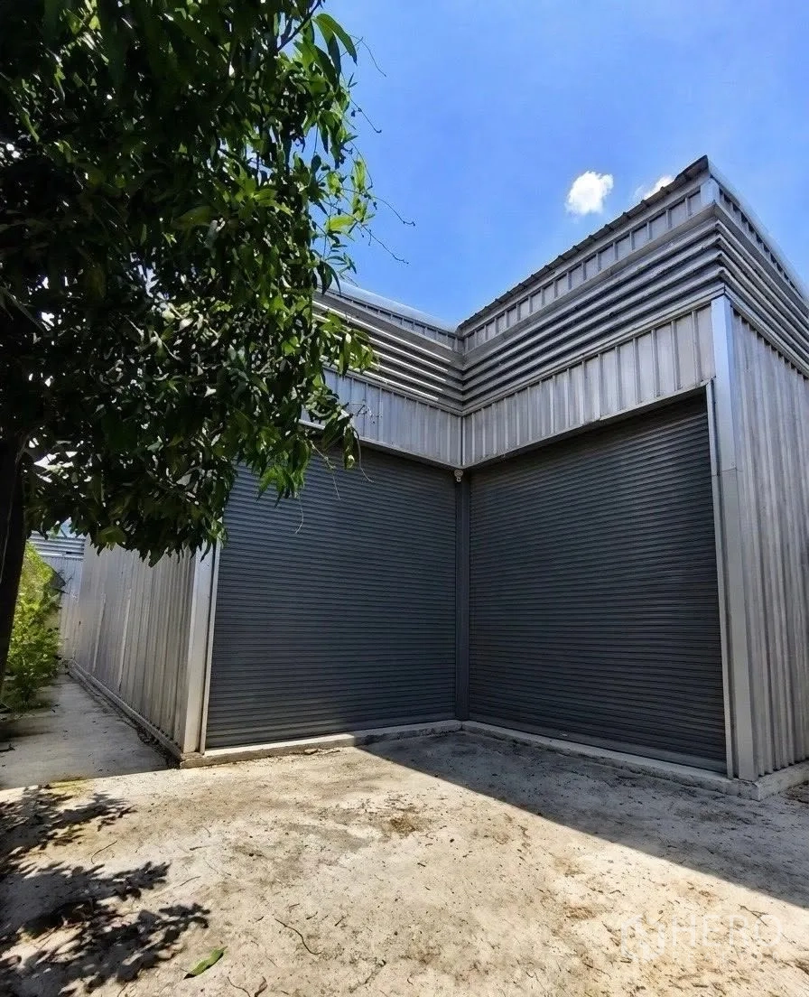 仓库 for rent in Don Mueang, Bangkok - 仓库外观，两扇大型卷帘门与前方混凝土作业区。