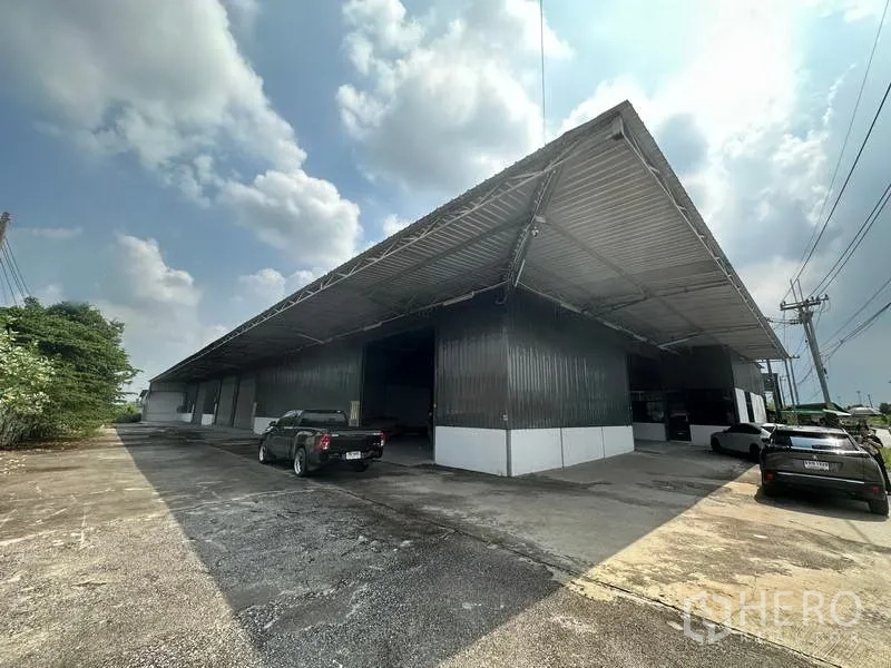 Warehouse for rent in Khlong Luang, Pathum Thani - Front elevation of corrugated warehouse showing drive-up access and wide canopy.