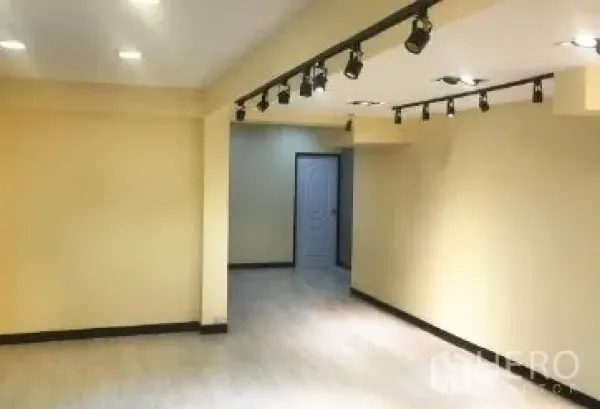 Office Space for rent in Bang Rak, Bangkok - Bright office interior featuring ceiling track lights, neutral walls and a door to a separate room.