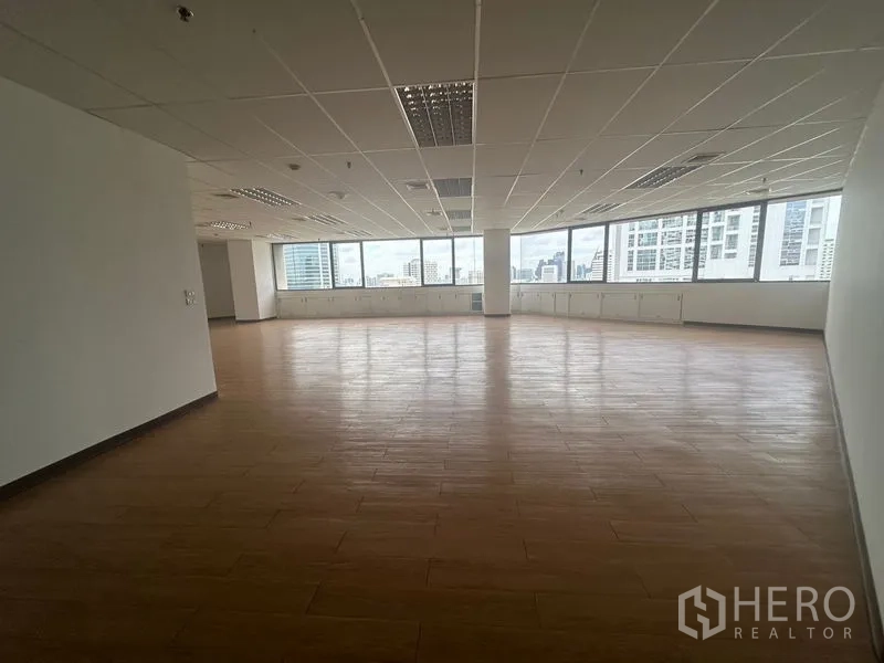 Office Space for rent in Bang Rak, Bangkok - Open-plan office floor with wood-look flooring, suspended ceiling and panoramic city views through corner windows in Bangkok CBD