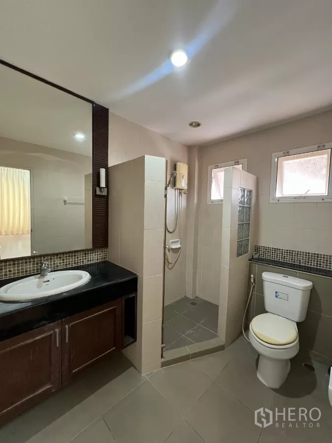 Detached House for rent in Bang Kapi, Bangkok - Bathroom with large mirror, vanity, separate shower area and toilet.