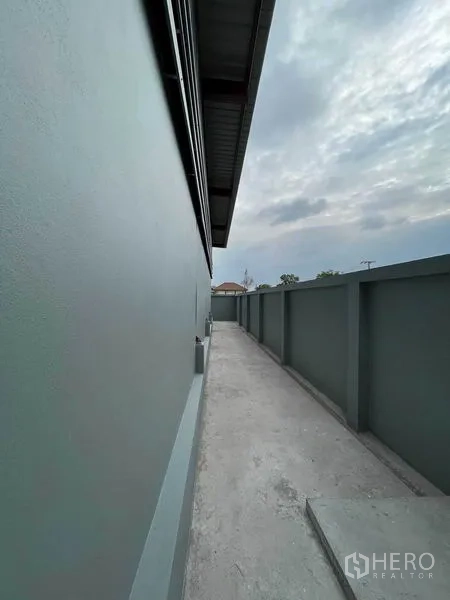 货栈 出租在Khlong Sam Wa, Bangkok - 沿仓库与围墙的狭长检修通道，天空多云。