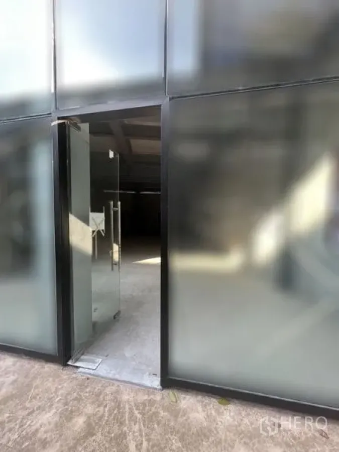 Retail Space for rent - Street-facing frosted glass shopfront with an open glass door to a retail space.