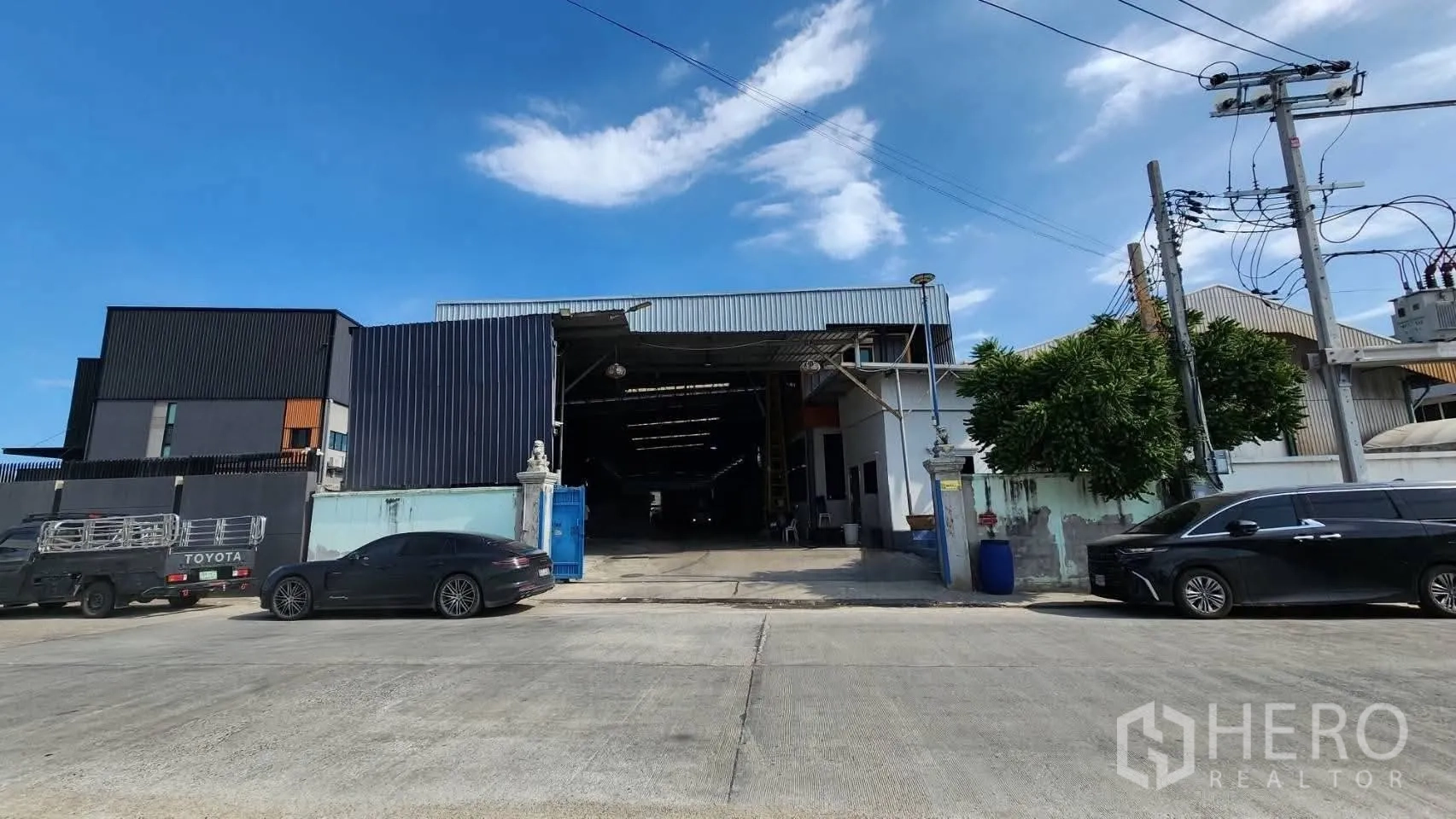 Warehouse for rent in Bang Phli, Samut Prakan - Street-facing exterior of the warehouse with a wide gated entrance and driveway suitable for truck access.