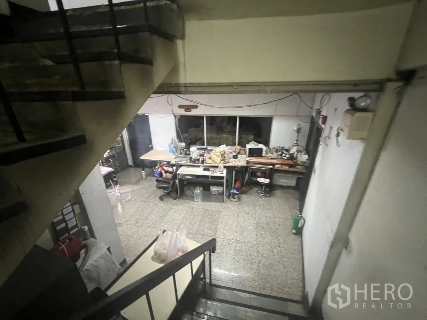 Shophouse for rent - View from stairwell over lower level office and work tables.