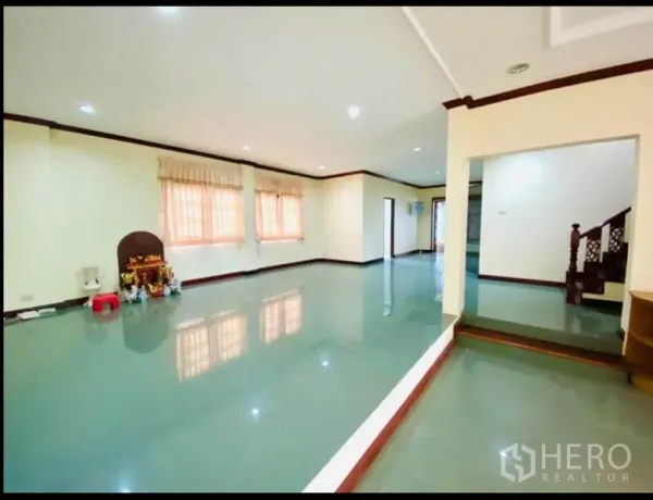 Factory for rent in Sam Phran, Nakhon Pathom - Spacious open-plan room with glossy tiled floors, downlights and a wooden staircase.