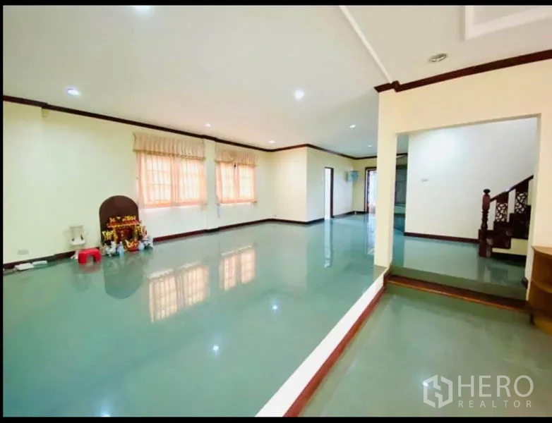Factory for rent in Sam Phran, Nakhon Pathom - Spacious open-plan room with glossy tiled floors, downlights and a wooden staircase.