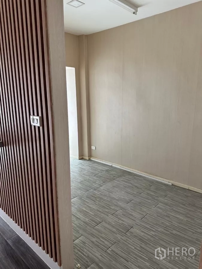 Shophouse for sale in Watthana, Bangkok - Room featuring vertical wood slat accent wall and tiled flooring.