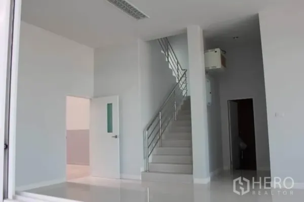 Factory for rent or sale in Lam Luk Ka, Pathum Thani - Bright ground-floor office lobby with white tiles and a staircase with stainless handrail.