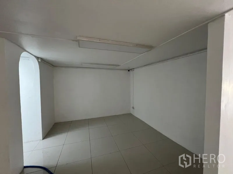 Retail Space for rent in Khlong Toei, Bangkok - Small back room with archway and tiled floor suitable for storage.