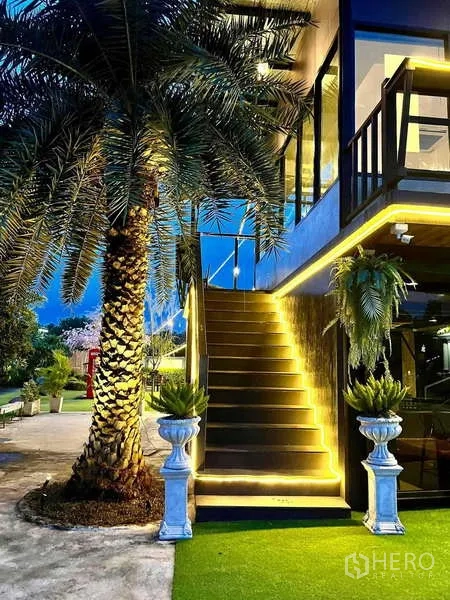 Detached House for sale in Khlong Luang, Pathum Thani - Exterior staircase with warm lighting next to a palm tree leading to the upper terrace.