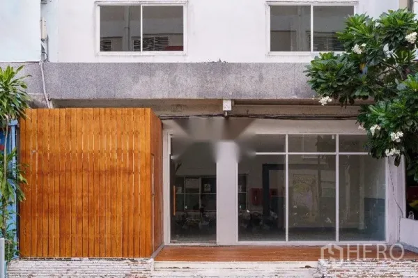 带办公室的家 出租在Khlong Toei, Bangkok - 临街立面，落地玻璃门搭配温暖木质隐私屏风的入口。