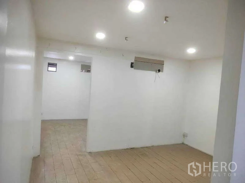 Shophouse for sale in Phra Khanong, Bangkok - Open-plan upper floor with recessed lighting and a wall AC point.