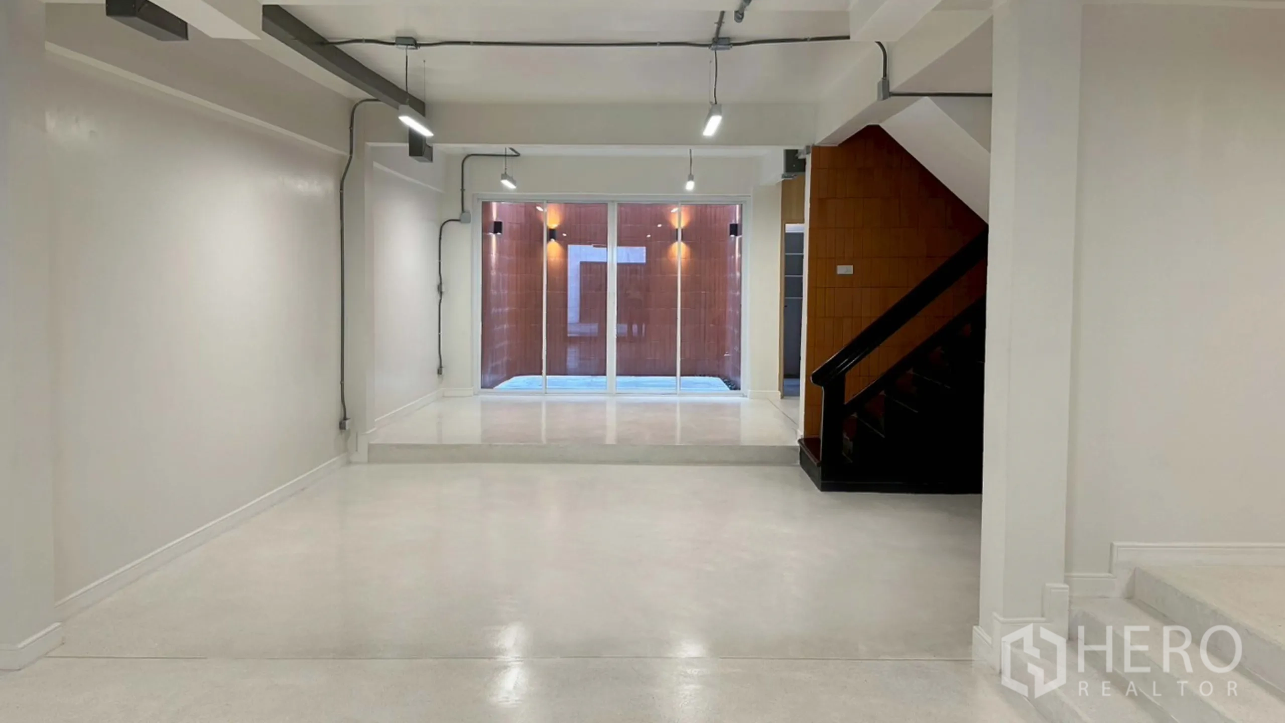 带办公室的家 出租在Watthana, Bangkok - 通向灯光天井的白色开放式空间与推拉门。