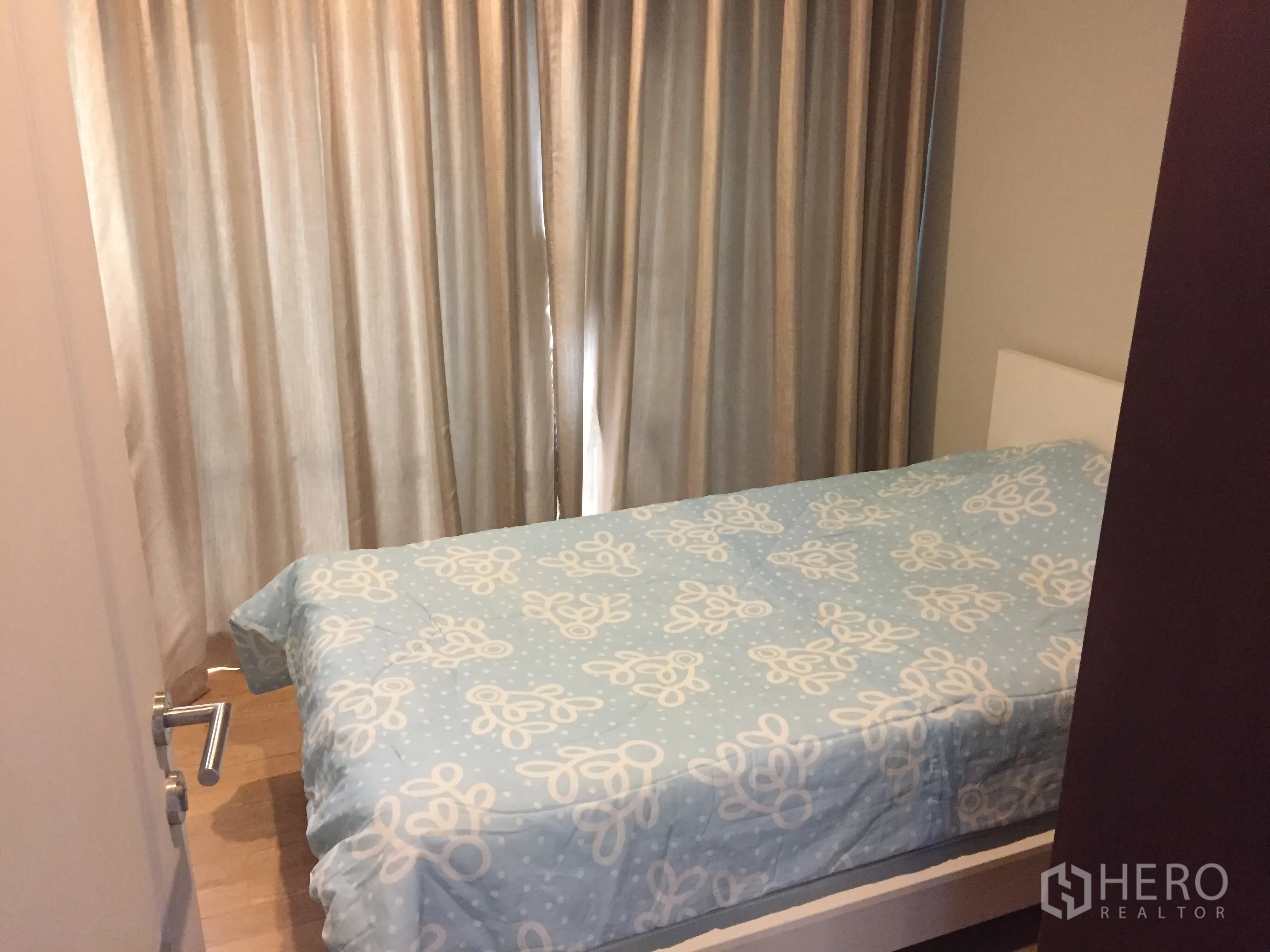 Condominium for rent in Bangkok - Cozy second bedroom with a single bed and full-length blackout curtains.