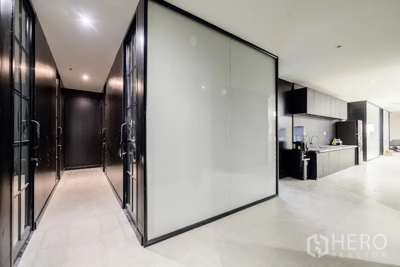 Office Space for rent or sale in Huai Khwang, Bangkok - Modern hallway with frosted glass partitions beside a built-in pantry and sink.