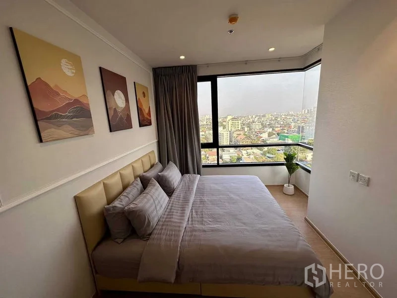 Condominium for sale - Master bedroom with large corner windows, neutral decor and open city views.