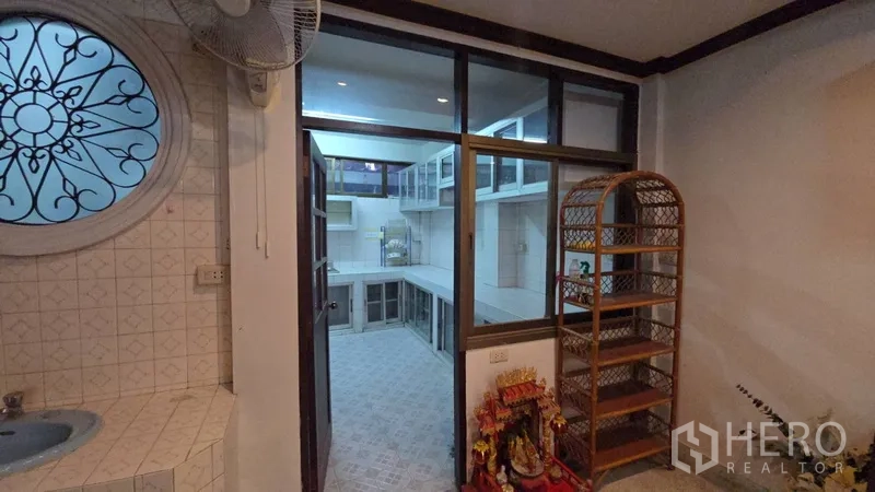 Home Office for rent in Sathon, Bangkok - View from pantry to the kitchen through glass partitions and a decorative round window.