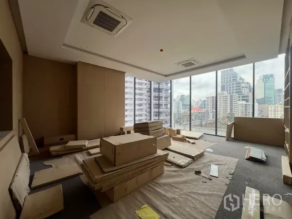 Retail Space for rent - Corner retail area under fit-out with floor-to-ceiling windows and Bangkok city skyline views.