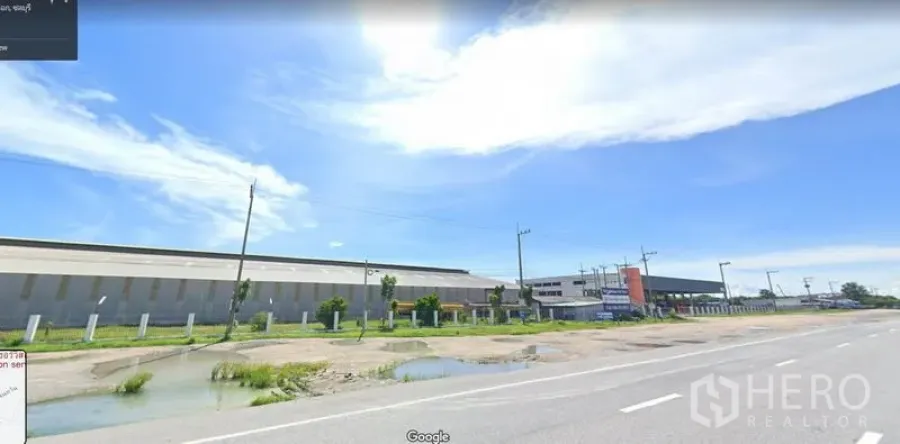 Warehouse for rent in Mueang Chon Buri, Chon Buri - Wide-road frontage of a large industrial warehouse complex under a bright sky in Mueang Chon Buri.