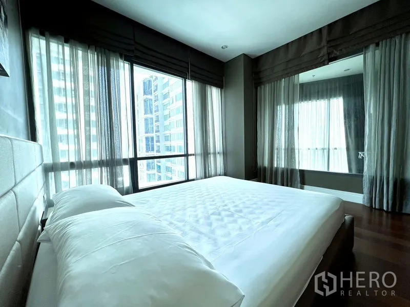 Condominium for rent in Khlong Toei, Bangkok - Bedroom featuring floor-to-ceiling windows and a skyline outlook.