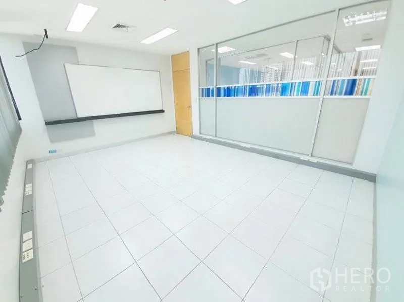 办公空间 出租在Bang Na, Bangkok - 瓷砖办公室，白板与带蓝色条纹磨砂膜的玻璃隔断。