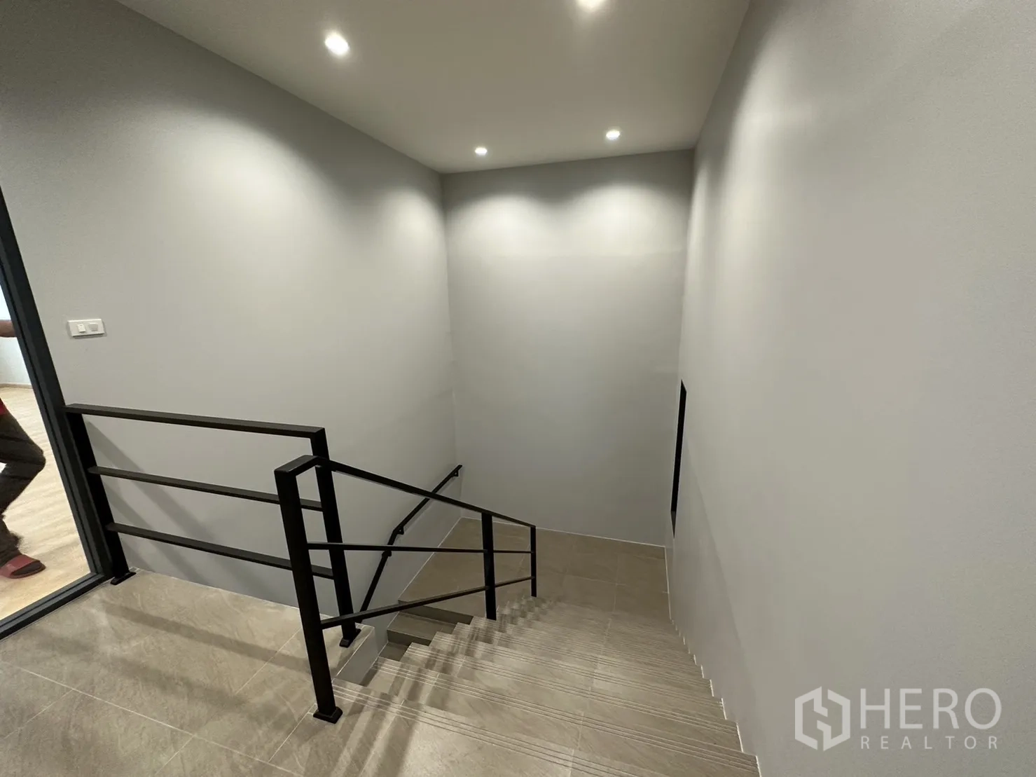Factory for sale in Lam Luk Ka, Pathum Thani - Stairwell with black metal handrail and recessed lighting.