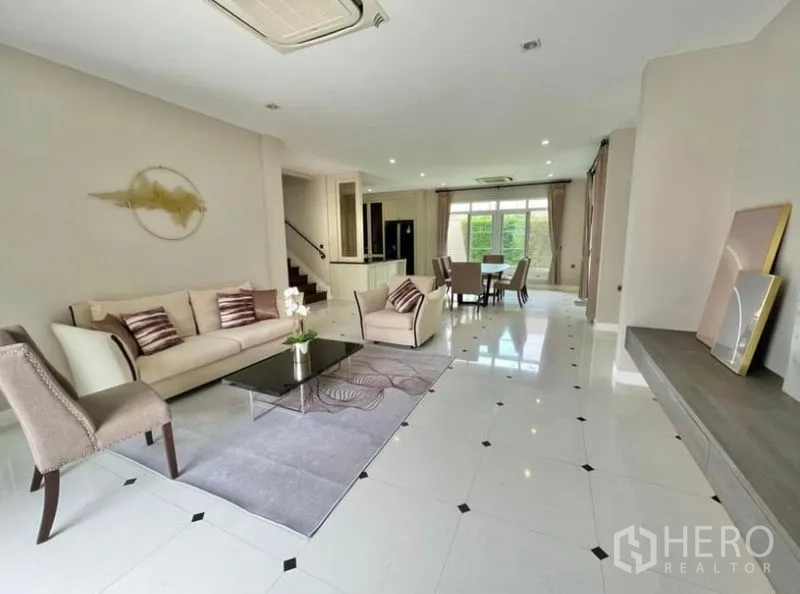 独立式住宅 出租在Bang Phli, Samut Prakan - 明亮的客餐厅一体空间，瓷砖地面与花园景观。