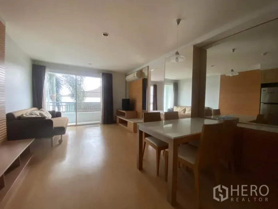Condominium for rent in Watthana, Bangkok - Open-plan living and dining room with sofa, dining set, TV console and balcony doors in a bright Ekkamai condo.
