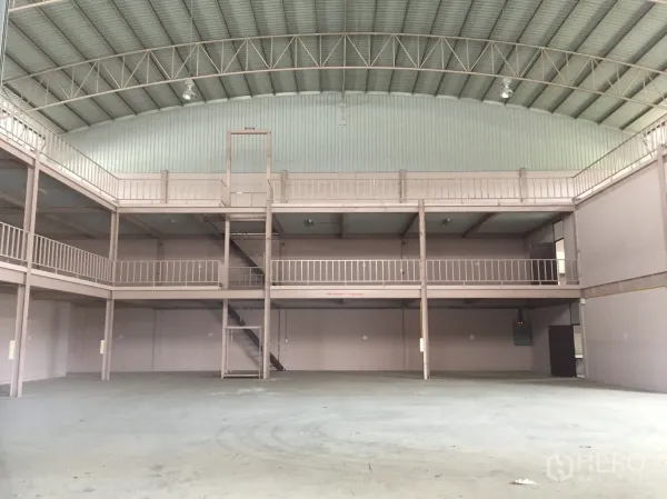 Factory for rent in Lam Luk Ka, Pathum Thani - Front view of expansive production hall with double mezzanine and central staircase.