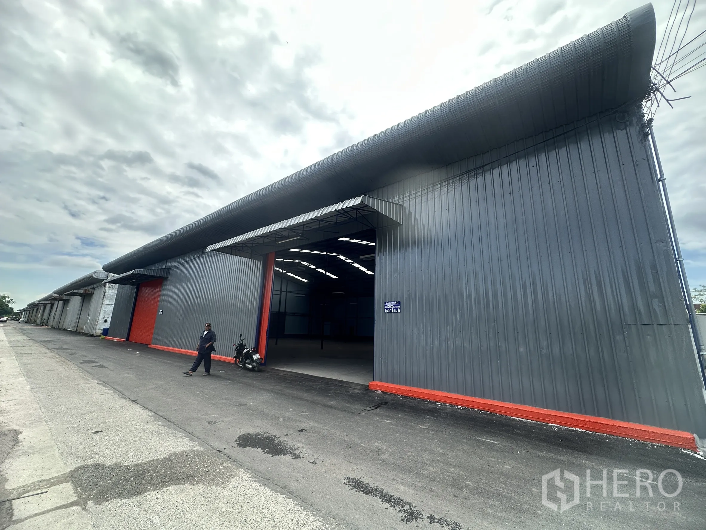 Warehouse for rent in Lat Krabang, Bangkok - Row of adjoining warehouse units with open bays along an access road.