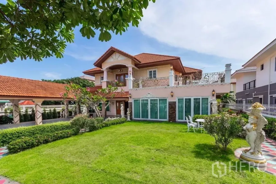 Detached House for rent or sale in Bang Khen, Bangkok - Two-story detached house with red tile roof, landscaped lawn, and wide terrace in Bang Khen.