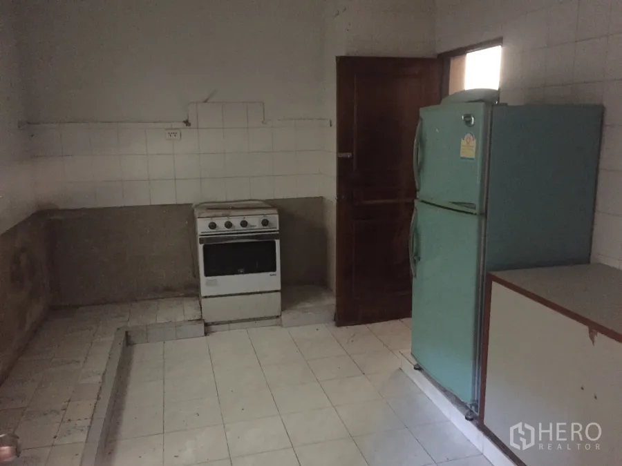 Home Office for sale in Watthana, Bangkok - Simple kitchen with freestanding oven and a double-door fridge in a tiled room.