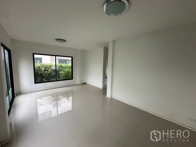 独立式住宅 出售在Bang Khen, Bangkok - 第二起居空间，落地窗面向花园绿意。