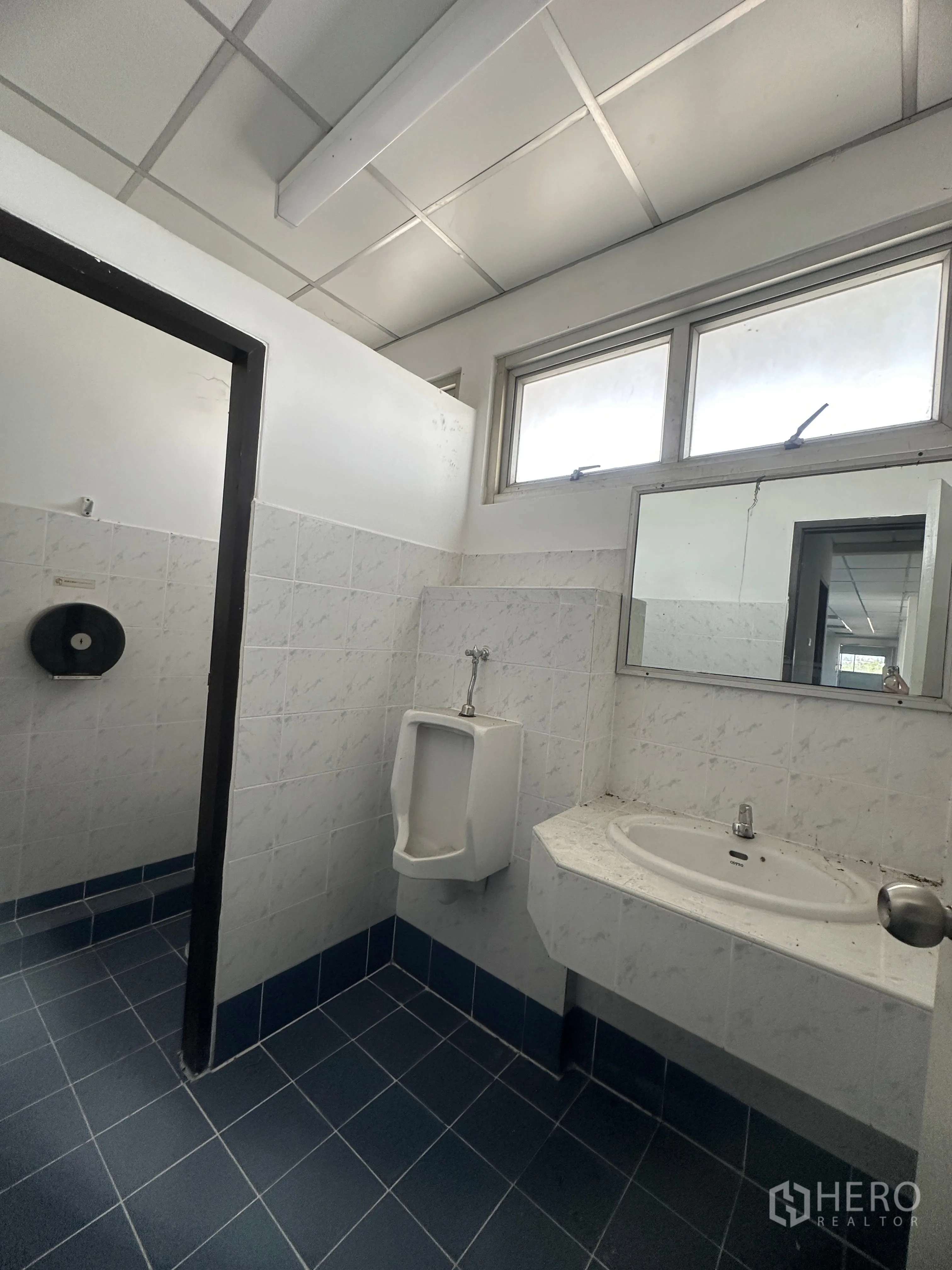 Factory for rent in Bang Pa-in, Phra Nakhon Si Ayutthaya - Restroom with tiled walls and floors, urinal, sink, and window.