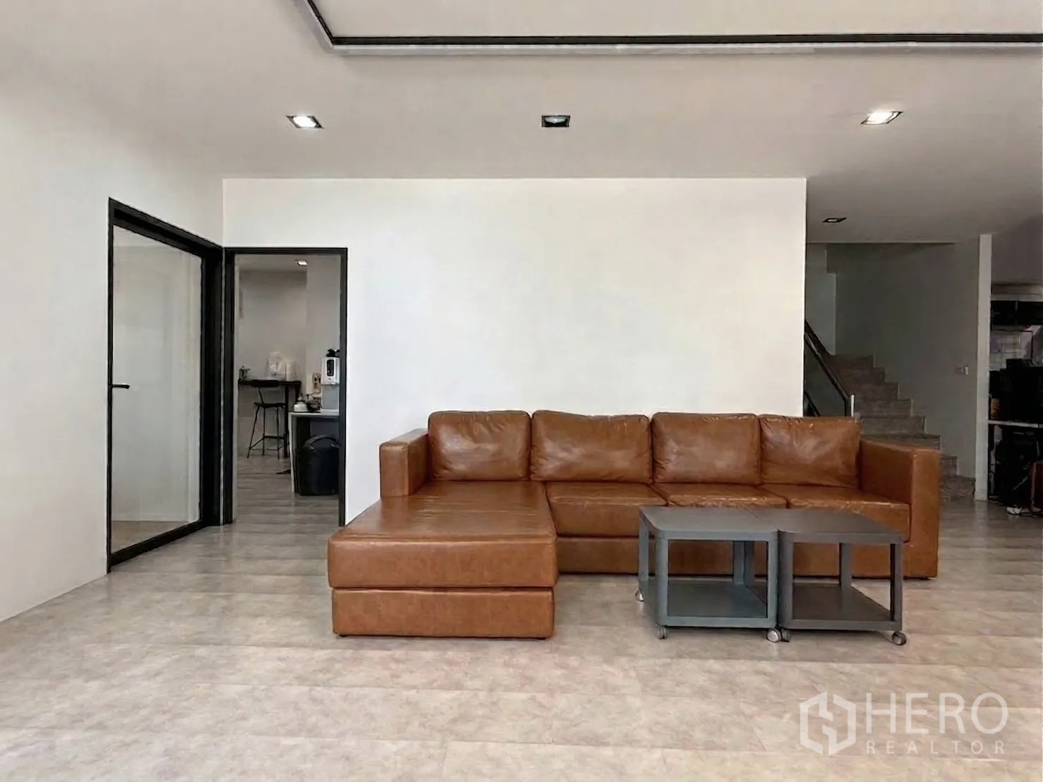 โฮมออฟฟิศ for rent in Watthana, Bangkok - มุมนั่งเล่นโซฟาหนังสีน้ำตาลพร้อมโต๊ะวางของ