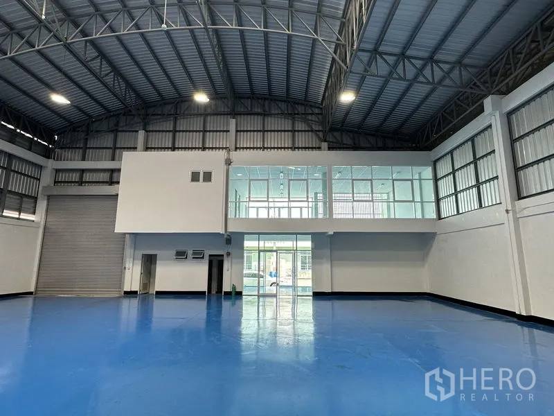 工厂 出租在Khlong Luang, Pathum Thani - 车间内景，装卸卷帘门及俯瞰生产区的夹层玻璃办公室。