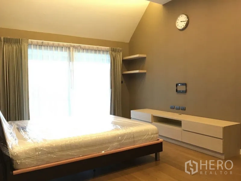 Detached House for rent or sale in Bang Kapi, Bangkok - Master bedroom with high ceiling, large window and built-in media unit.