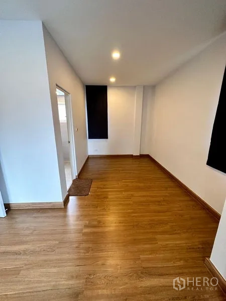 Detached House for sale in Prawet, Bangkok - Flexible room with wood flooring, recessed lighting and adjacent bathroom door.