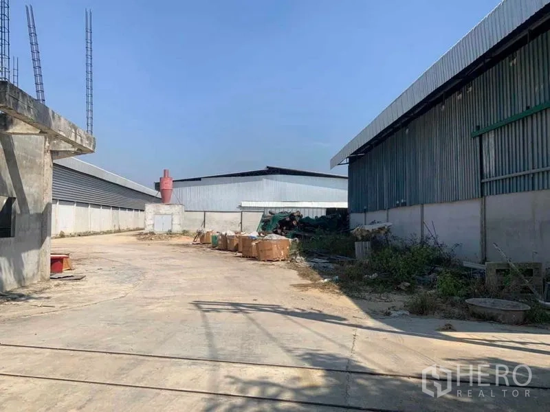 Factory for rent in Nakhon Pathom - Concrete yard between warehouse buildings for loading and parking.
