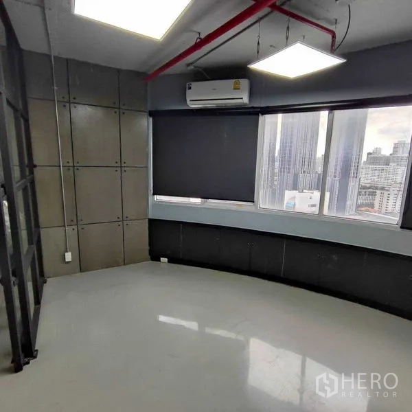 Office Space for rent in Watthana, Bangkok - Curved corner room with roller blinds, air conditioner and large windows overlooking the city.