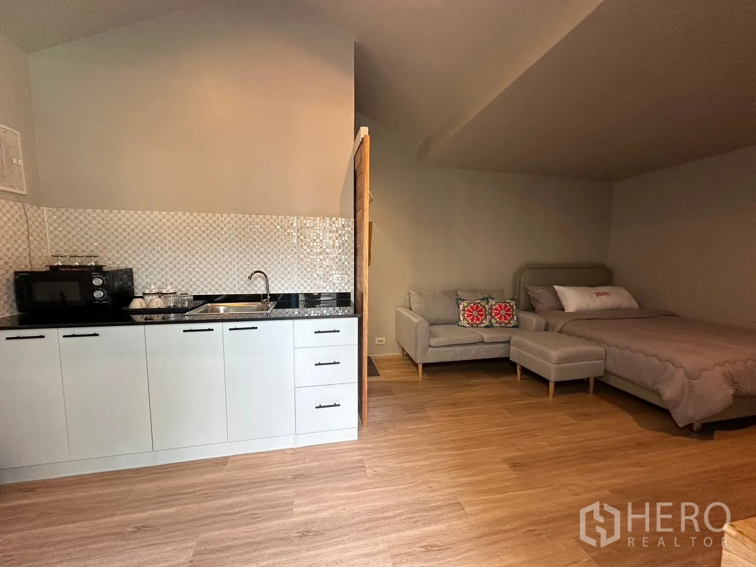 Home Office for rent in Suan Luang, Bangkok - Poolside studio with kitchenette, sofa, and bed.