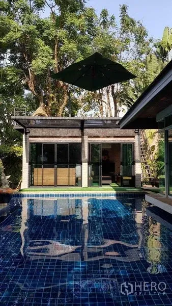 Detached House for sale in Bang Na, Bangkok - Private blue-tiled swimming pool beside a poolside pavilion under tall trees.