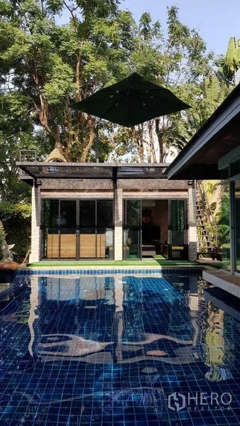 Detached House for sale in Bang Na, Bangkok - Private blue-tiled swimming pool beside a poolside pavilion under tall trees.