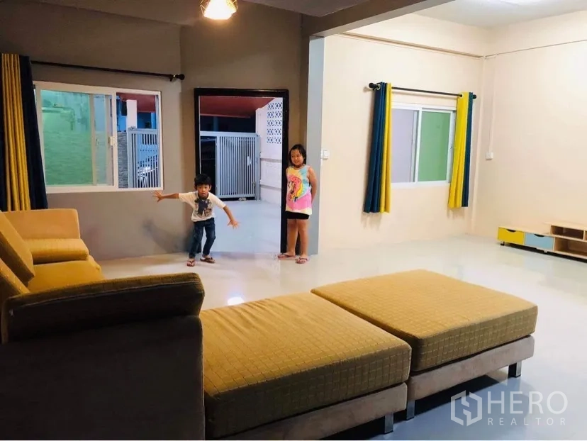 Townhouse for rent or sale in Huai Khwang, Bangkok - Large lounge with multiple windows, neutral walls and polished tile flooring.